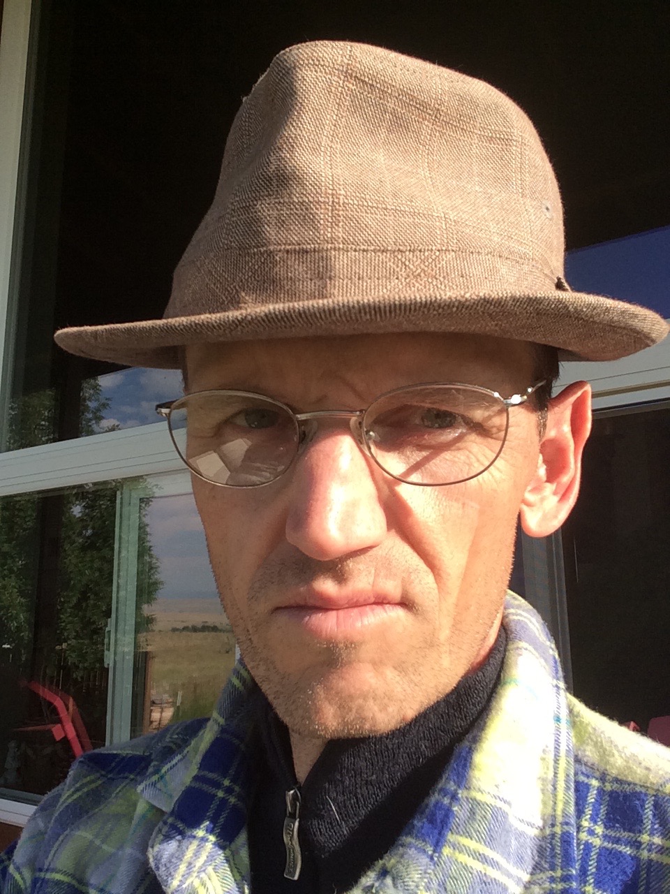 Color headshot of Michael Earl Craig, wearing a hat and spectacles