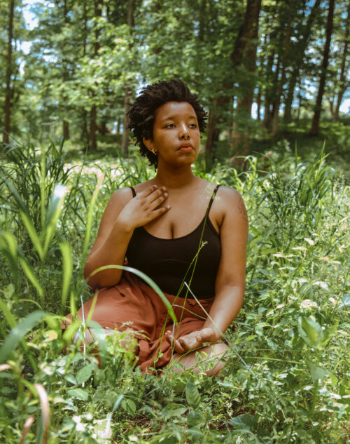 Image of poet Destiny Hemphill sitting in a field