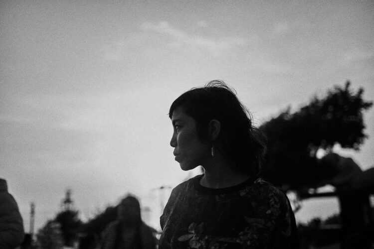 A black and white photo of a woman looking off into the distance